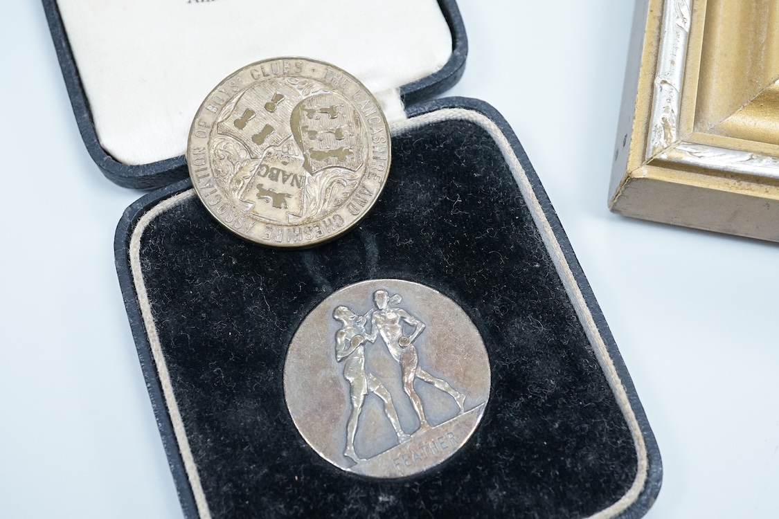 Framed group of eight WWI and WWII medals including a First World War medal pair, the Africa star, the Atlantic star, etc. a hallmarked silver boxing medal and another, both cased, plus a Lancashire and Cheshire Associat